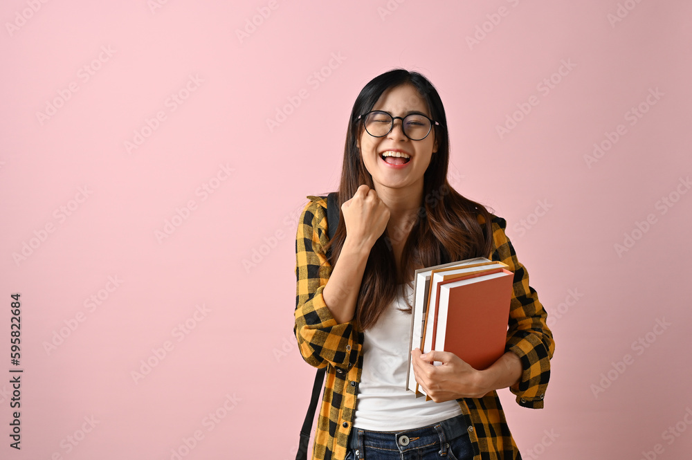 Cheerful Asian female college student rejoicing and celebrating gesture Cheerful Asian female college student rejoicing and celebrating gesture