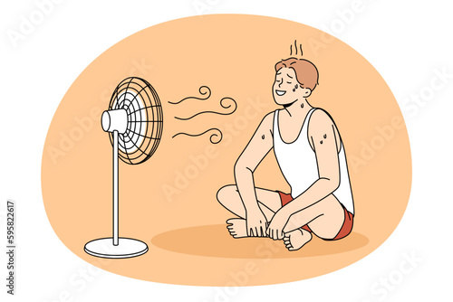 Sweating and cooling air concept. Young positive man in sportswear sitting on floor sweating and enjoying work on air fan wind vector illustration