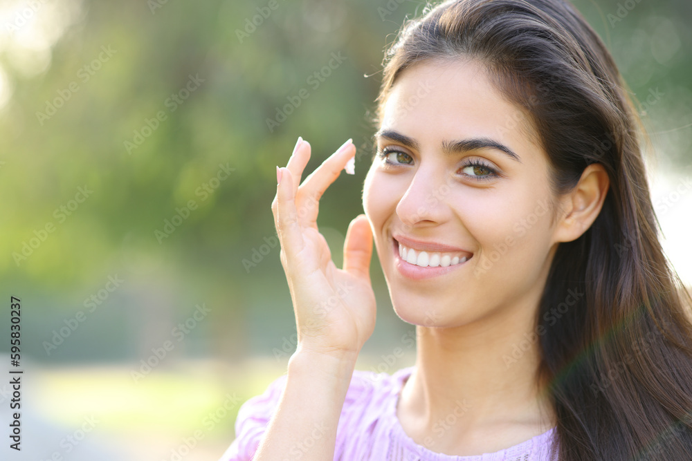 Beauty woman hydrating face skin with cream