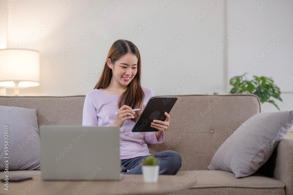 pretty young woman using her digital tablet for reading while sitting on sofa at home. pretty young woman using her digital tablet for reading while sitting on sofa at home.