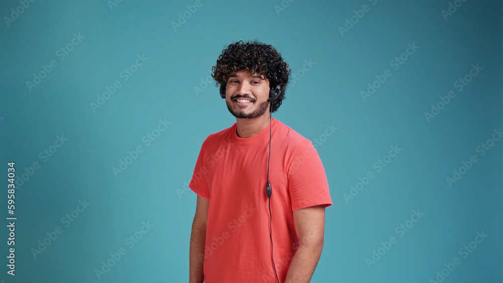 latin male call center operator in Casual smiling on studio blue background latin male call center operator in Casual smiling on studio blue background
