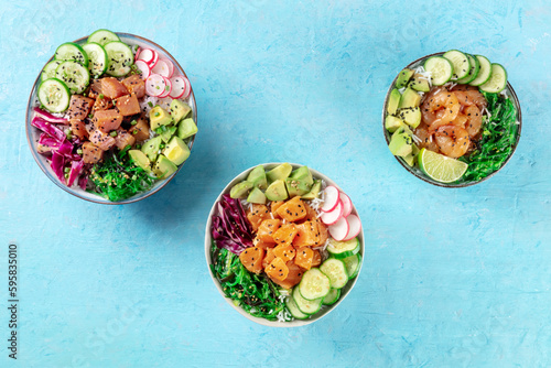 Poke bowl variety. Healthy Hawaiian dish with salmon, tuna, and shrimps, overhead flat lay shot on a blue background
