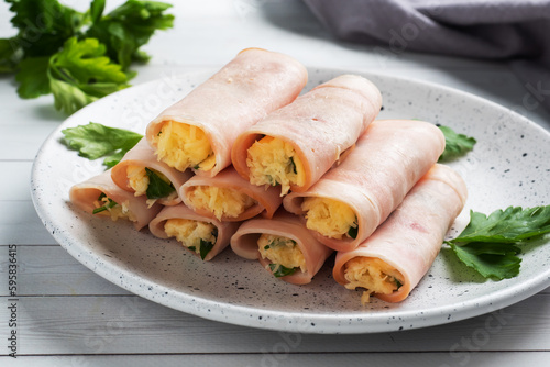 Ham and cheese rolls on a plate. Delicious appetizer meat carbonate and cream cheese.