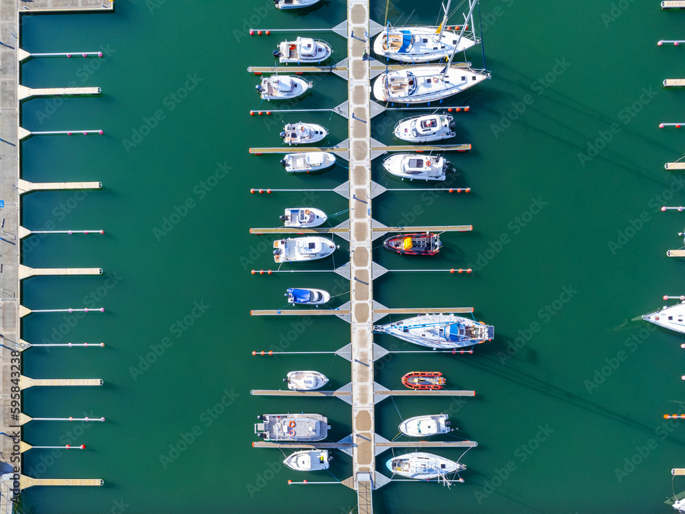 Aerial view of the many white yachts and sailboats moored in the marina on the turquoise water, summer season. Harbor in Poland Gdynia.