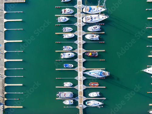 Obraz na płótnie Aerial view of the many white yachts and sailboats moored in the marina on the turquoise water, summer season. Harbor in Poland Gdynia. w salonie