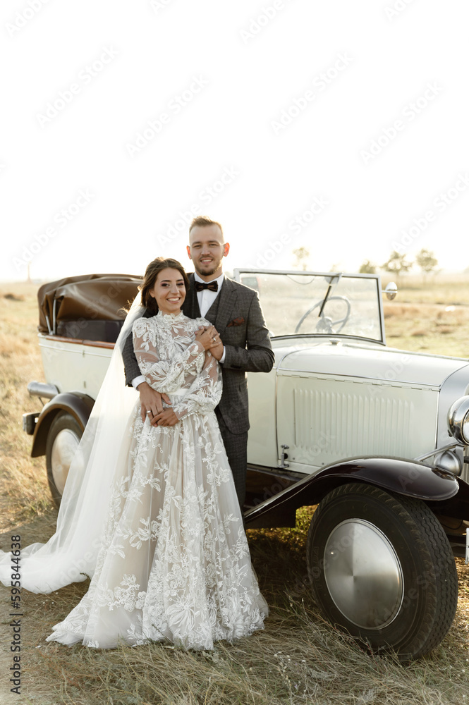 Fototapeta premium newlyweds in a retro cabriolet. rustic wedding. beautiful nature overlooking the sea. collector's wedding car
