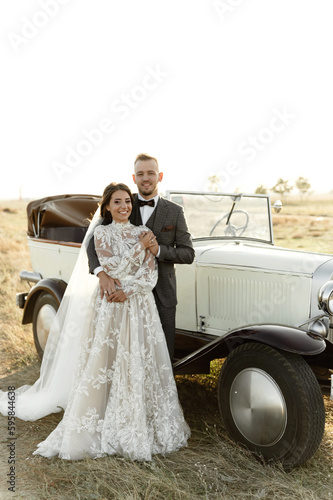 newlyweds in a retro cabriolet. rustic wedding. beautiful nature overlooking the sea. collector's wedding car