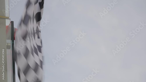 Man holding and waving Checkered race at finish line on a raceway F1. Victory, achievement, success and sport concept. 