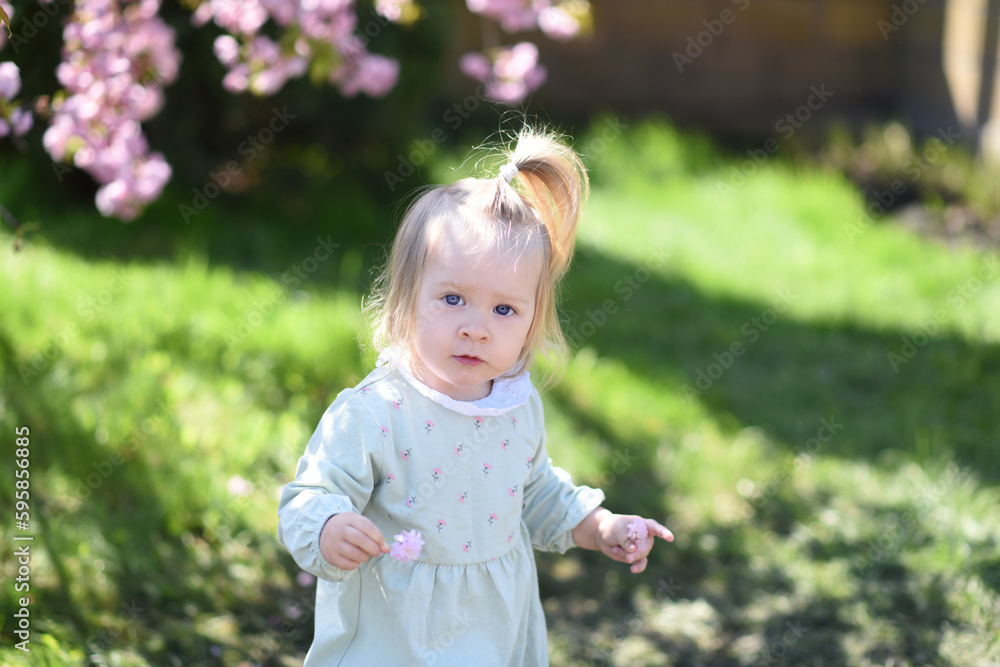 girl in the park with flowers. little girl in the garden girl in the park with flowers. little girl in the garden