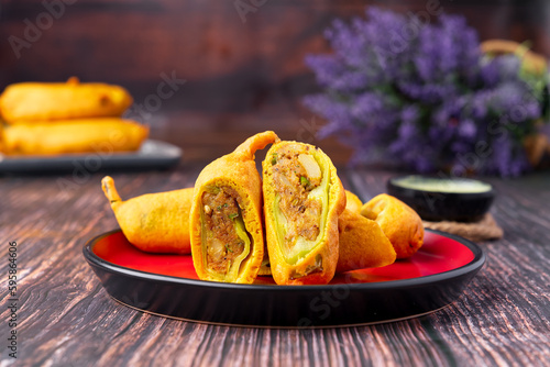 Mirchi bada is a spicy Indian snack consisting of chili and potato or cauliflower stuffing battered and fried, served hot with tomato sauce or occasionally with mint and tamarind chutney