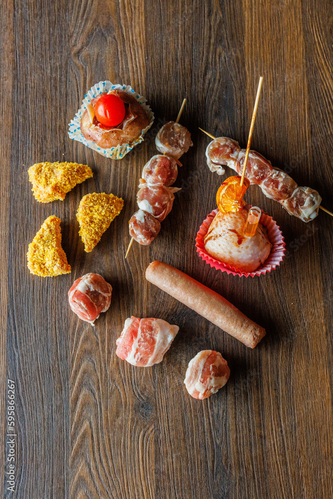 Composizione di diverse lavorazioni di carne di una macelleria poggiate su un tavolo di legno e fotografate dall'alto Composizione di diverse lavorazioni di carne di una macelleria poggiate su un tavolo di legno e fotografate dall'alto