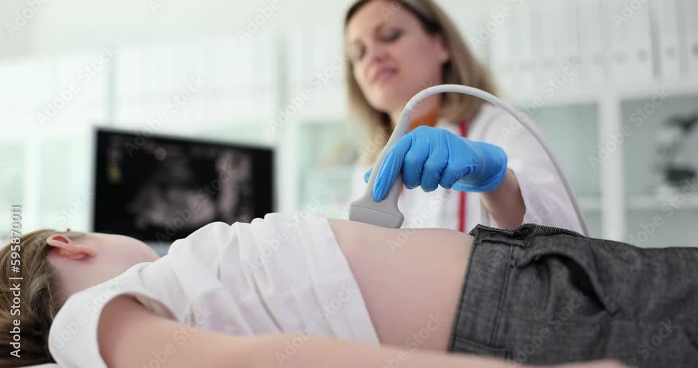 Doctor makes ultrasound of abdomen and internal organs of child. Abdominal pain causes symptoms and diagnosis Doctor makes ultrasound of abdomen and internal organs of child. Abdominal pain causes symptoms and diagnosis