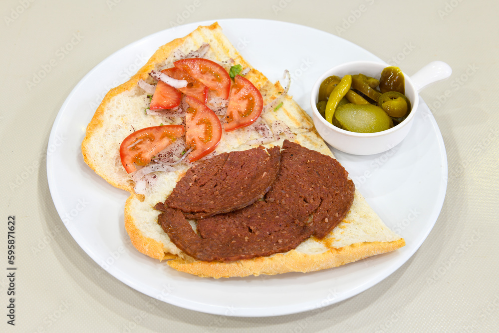 Close-up shot of Izmir's famous Turkish Traditional Kumru Sandwich, Çeşme Kumru , ingredients ready to eat salami, sucuk , tomato, cheddar cheese and fried cheese. Yengen eritme karisik sandvic.