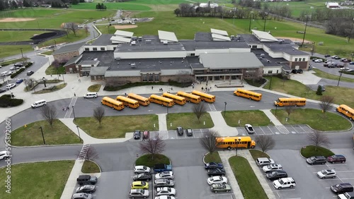 Aerial of public school campus in USA with yellow school bus vehicle to transport students. Education in America theme. photo