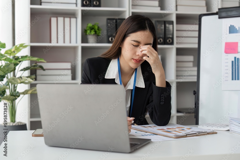 Businesswoman are stressed while working on laptop tired with headache at office, feeling sick at work Businesswoman are stressed while working on laptop tired with headache at office, feeling sick at work
