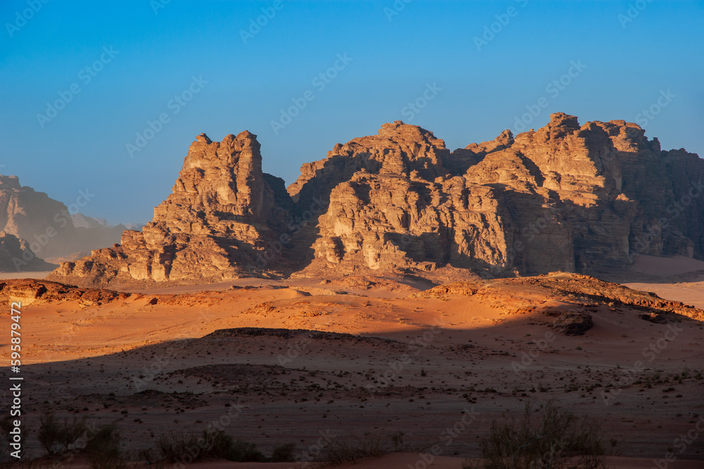 Magic mountain landscapes of Wadi Rum Desert, Jordan. Mountains in lifeless desert resemble Martian craters.  Sand is beautiful pink color and and red rocks. There is place for text.