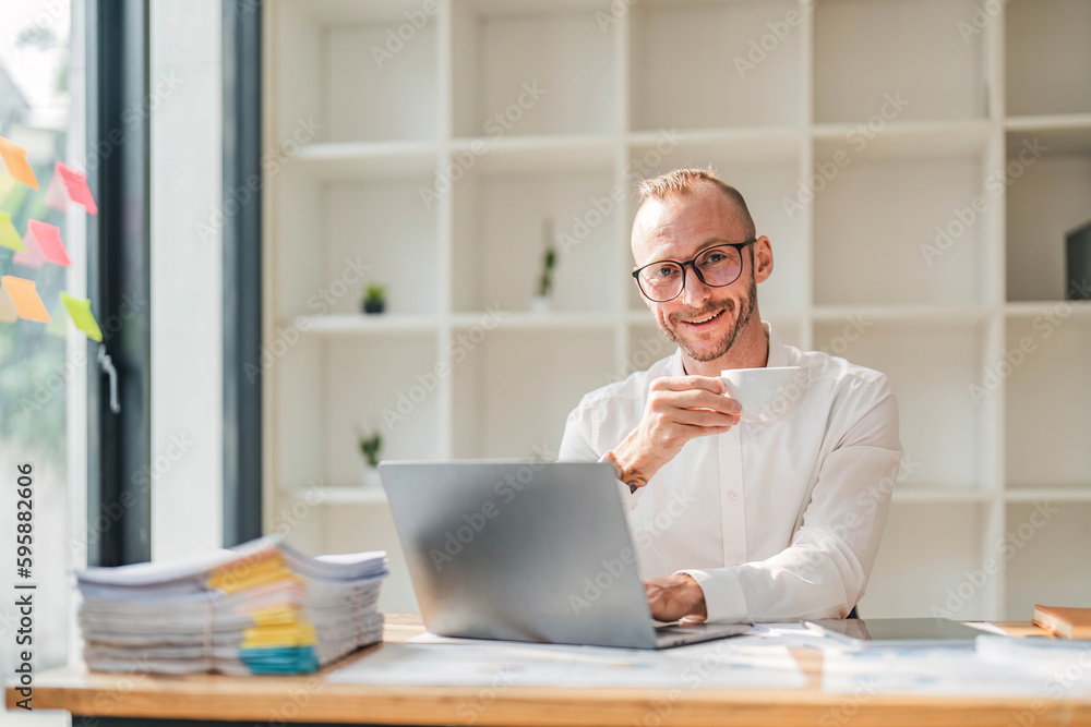 Serious Businessman Working At Laptop Computer Typing Something In Office. Business Career Concept. Copy Space Serious Businessman Working At Laptop Computer Typing Something In Office. Business Career Concept. Copy Space