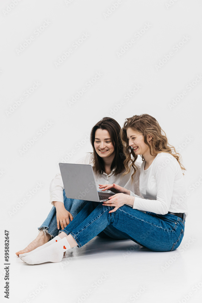 Young happy couple of young women on white background communicate showing laptop together. Chroma Key
