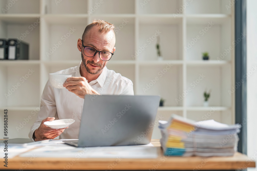 Serious Businessman Working At Laptop Computer Typing Something In Office. Business Career Concept. Copy Space Serious Businessman Working At Laptop Computer Typing Something In Office. Business Career Concept. Copy Space