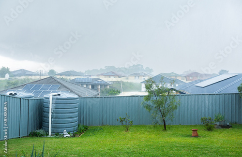 Heavy rainfall in backyard with water overflowing from tank photo
