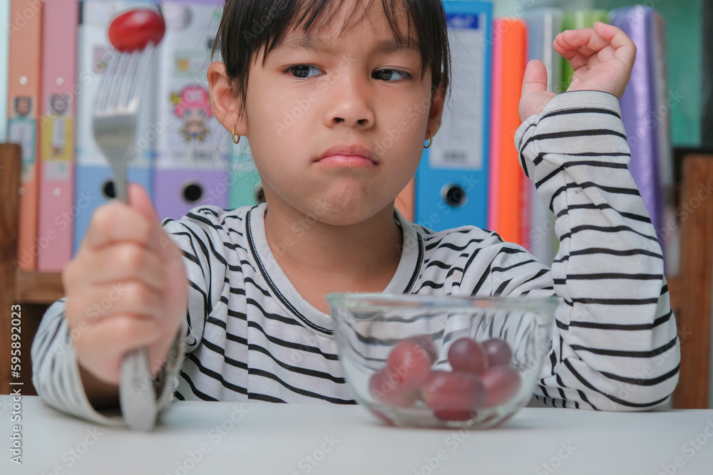 Foto de Children don't like to eat fruits. Cute young Asian girl ...