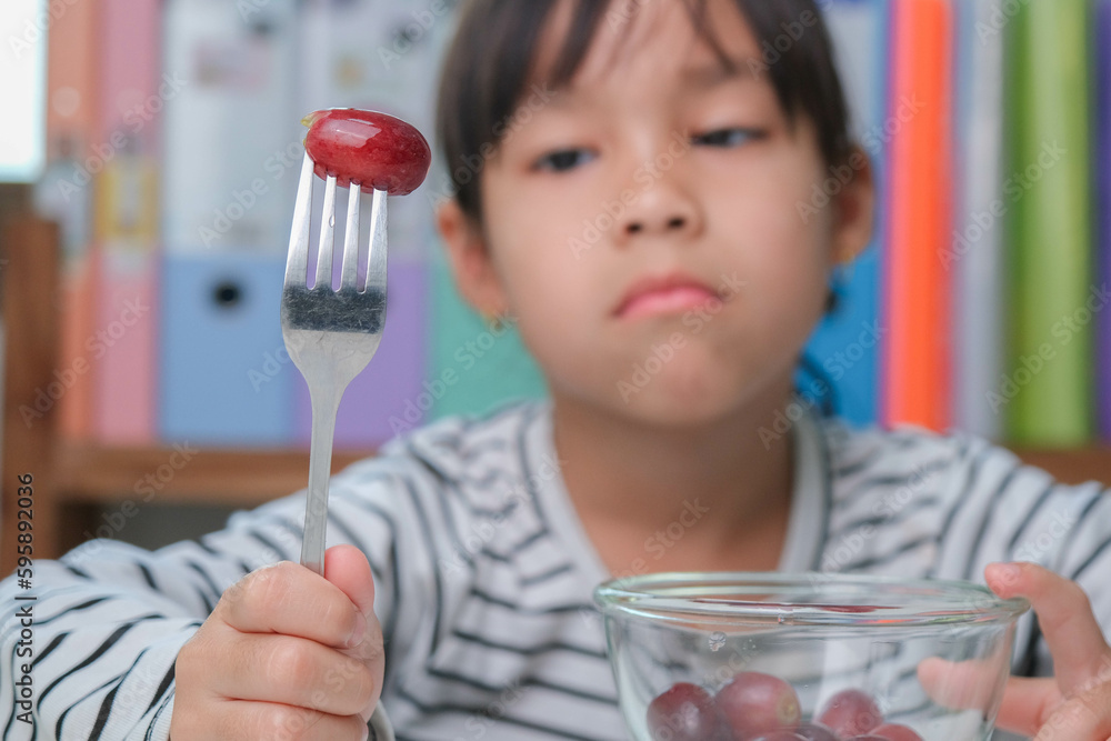 Children don't like to eat fruits. Cute young Asian girl refusing to ...