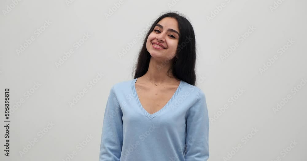 Portrait of smiling young woman in blue top feeling glad over white background Portrait of smiling young woman in blue top feeling glad over white background