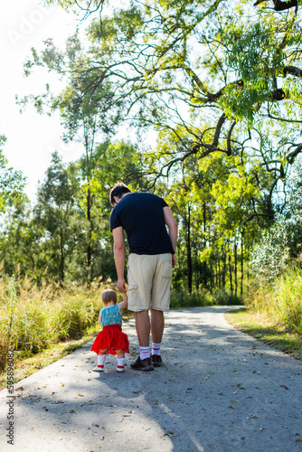 Father and daughter walking along path - toddler walk with parent photo