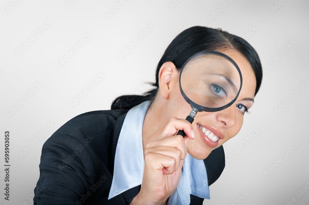 Happy young women entrepreneurs looking in magnifying glass Happy young women entrepreneurs looking in magnifying glass