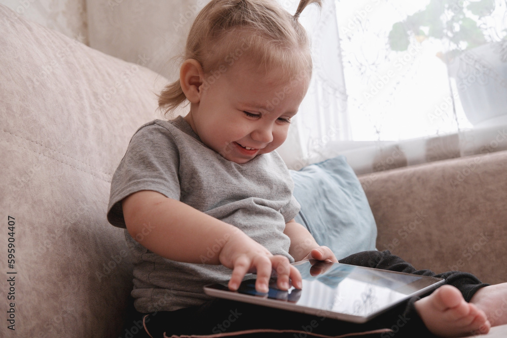 Happy little child sitting on sofa and using tablet. Happy little child sitting on sofa and using tablet.