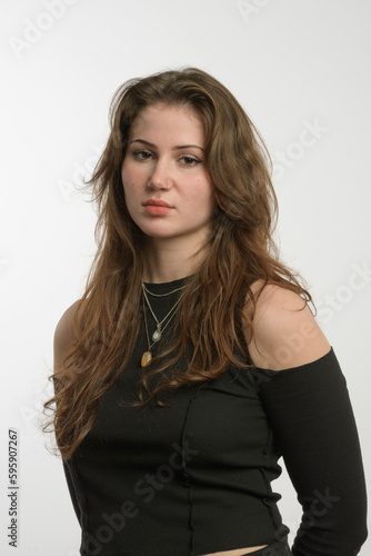 Portrait of a young girl, brunette without deep retouching. natural skin of the face. White background. studio portrait