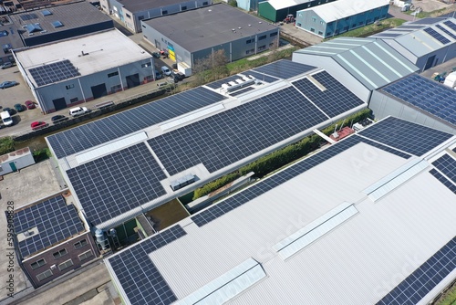 Company,s buildings with solar panels in a row on a roof.Photo taken with a drone.Photovoltaic modules for renewable energy.Save the earth and the energy with good environment concept. 