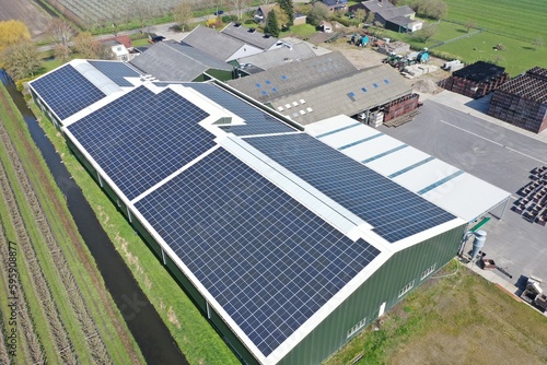 Company,s buildings with solar panels in a row on a roof. 

Photo taken with a drone.

Photovoltaic modules for renewable energy.Save the earth and the energy with good environment concept.
