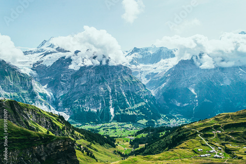 Summer mountain landscape with green grass and mountain peaks.