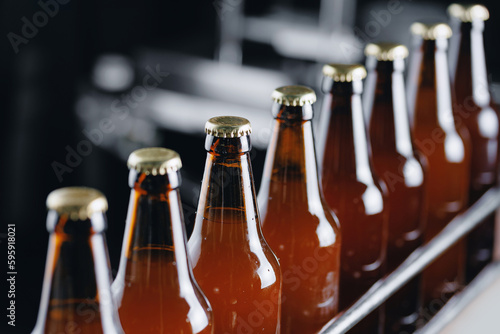 Brewery plant production line  Glass bottles of beer on dark background