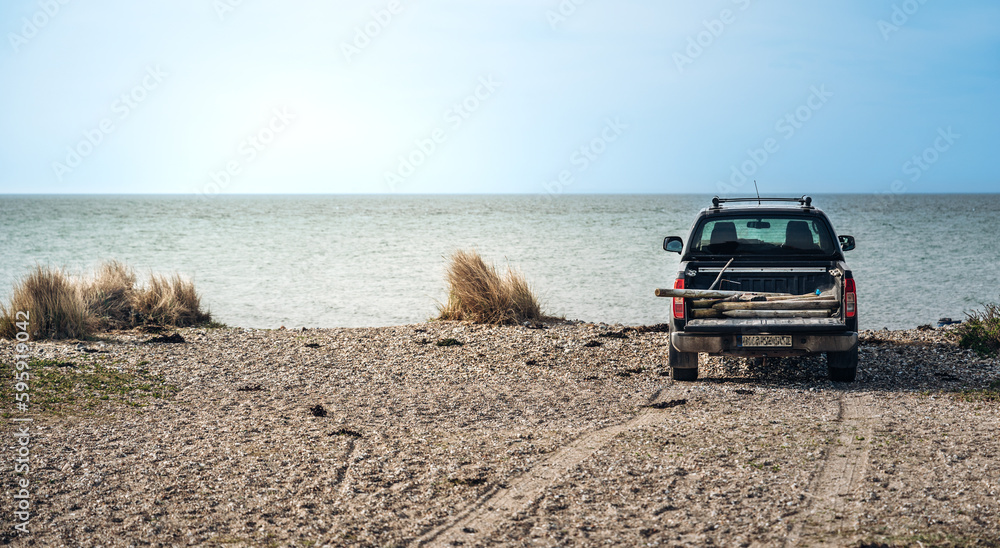 Strandlandschaft mit Auto bei blauem Himmel. Cooles Auto, Pick up parkt direkt am Strand. Strandlandschaft mit Auto bei blauem Himmel. Cooles Auto, Pick up parkt direkt am Strand.