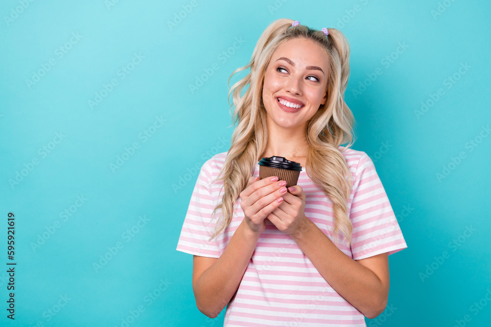 Photo of lovely positive girl hands hold coffee cup look empty space toothy smile isolated on teal color background Photo of lovely positive girl hands hold coffee cup look empty space toothy smile isolated on teal color background