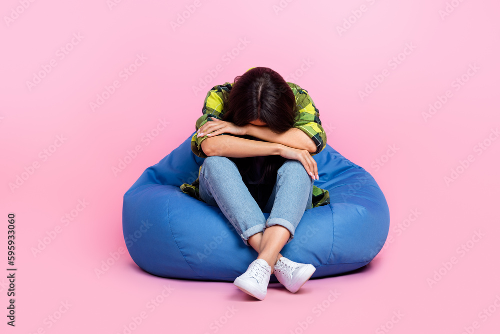 Full length photo of bored depressed woman dressed plaid shirt sitting bean bag sleeping napping isolated pink color background Full length photo of bored depressed woman dressed plaid shirt sitting bean bag sleeping napping isolated pink color background