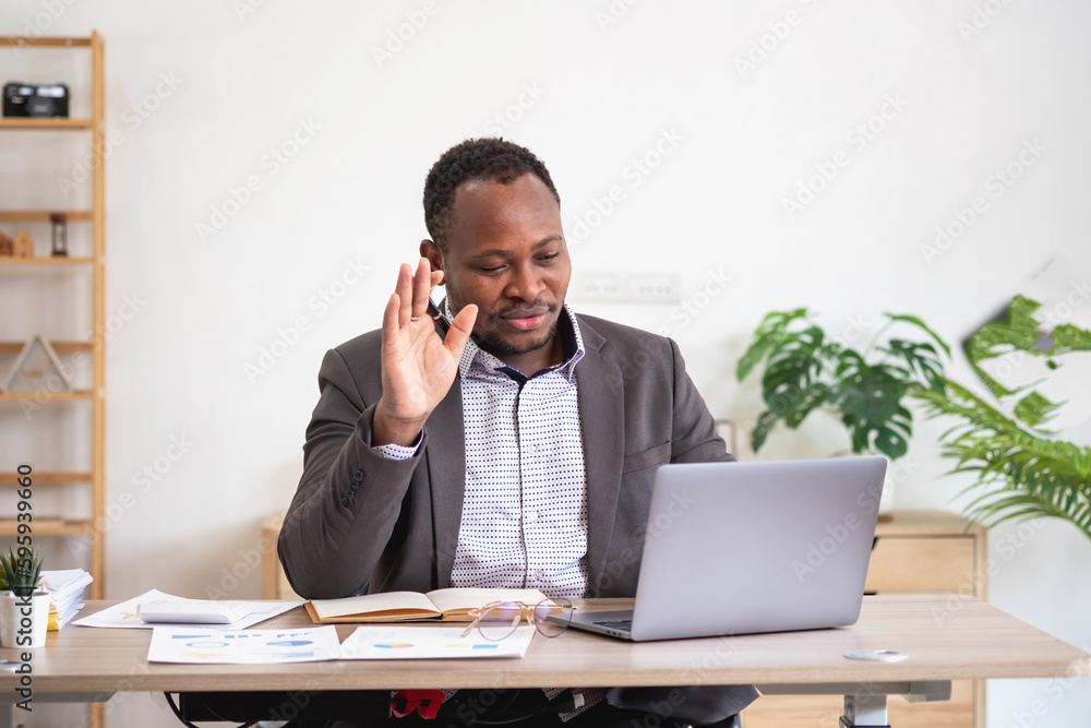 African American businessman analyzing laptop graph paperwork in office holding documents preparing portfolio analysis report Black male analyst doing paperwork in the workplace using the computer. African American businessman analyzing laptop graph paperwork in office holding documents preparing portfolio analysis report Black male analyst doing paperwork in the workplace using the computer.