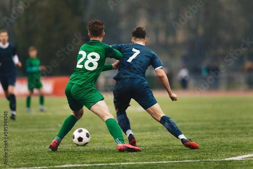 Two College Soccer Teams Playing Soccer League Game. Adult Soccer Players in a Duel. Two Football Players Competing in a Game. European Soccer Tournament Match For Adult Players. © matimix