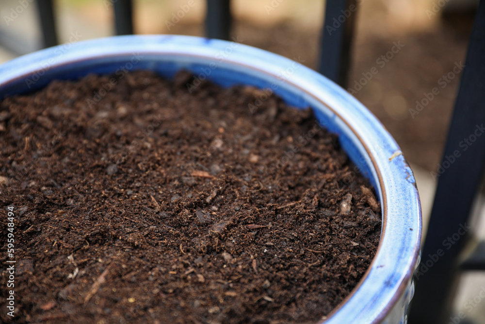 A flower pot with dirt symbolizes growth, potential, and nurturing. It represents the beginning stages of a plant's life and the care needed for it to thrive