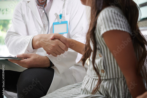 Pediatrician shaking hand of preteen patient before explaining her diagnosis