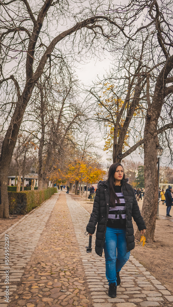 Latin woman walking in El Retiro park in Madrid.