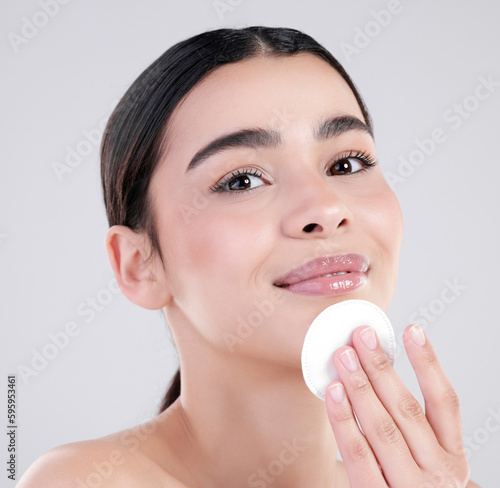 Time to exfoliate. Studio portrait of an attractive young woman exfoliating her face against a grey background.