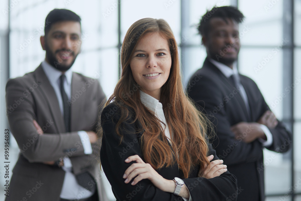 Three multiethnic workers in formal suits standing for camera indoors and smiling. Three multiethnic workers in formal suits standing for camera indoors and smiling.