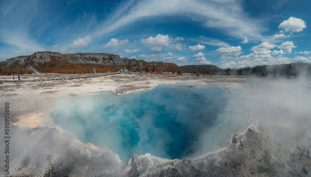 Sapphire Pool at the Biscuit Basin in Yellowstone National Park, Wyoming. Sunny sky with clouds. Sapphire Pool at the Biscuit Basin in Yellowstone National Park, Wyoming. Sunny sky with clouds.