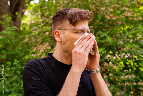 Young adult man having trouble with pollen seasonal allergies 