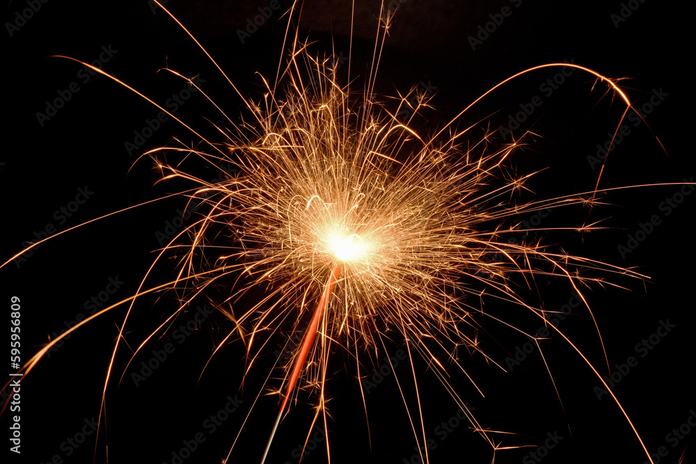 sparkler with sparks close up on black background