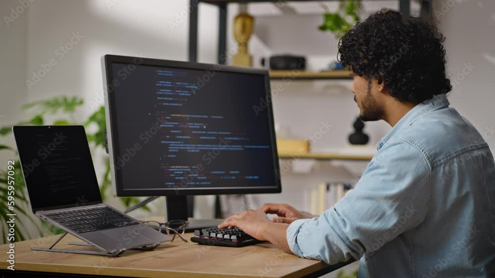 Hindus programmer works sitting at desk in cozy apartment Hindus programmer works sitting at desk in cozy apartment