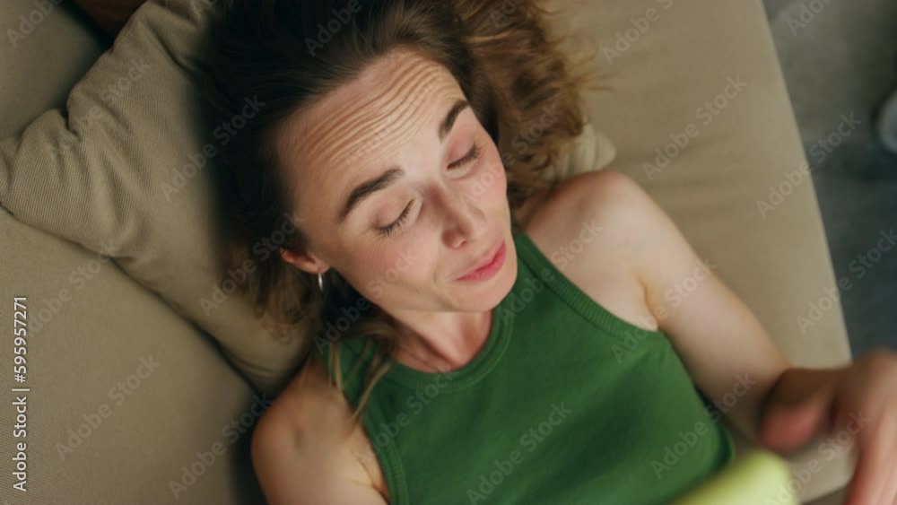 Smiling woman videocalling telephone laying sofa closeup. Happy girl talking Smiling woman videocalling telephone laying sofa closeup. Happy girl talking